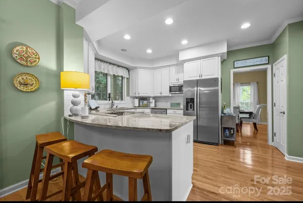 a kitchen with stainless steel appliances granite countertop a sink and a refrigerator