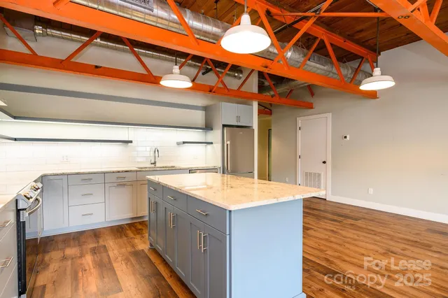 a kitchen with a sink cabinets and wooden floor