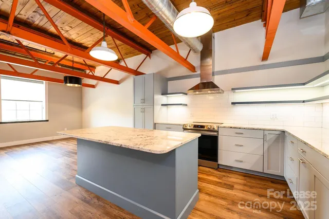 a kitchen with stainless steel appliances granite countertop a sink dishwasher and stove with wooden floor