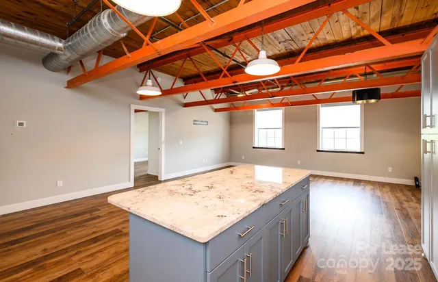 a kitchen with a sink a stove and a wooden floor