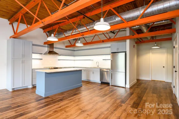 a kitchen with stainless steel appliances granite countertop a sink and wooden floors