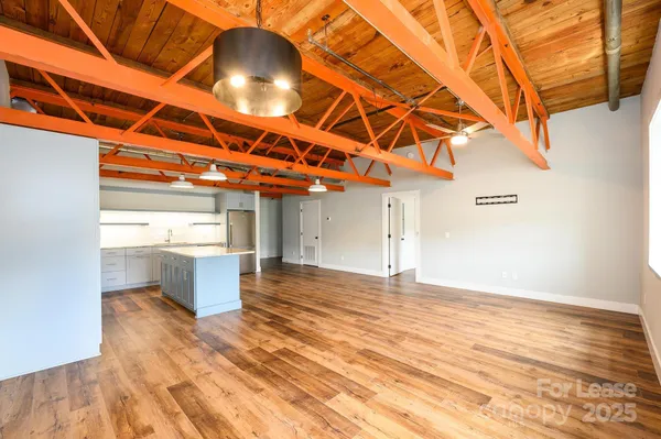 a view of a room with wooden floor and a window