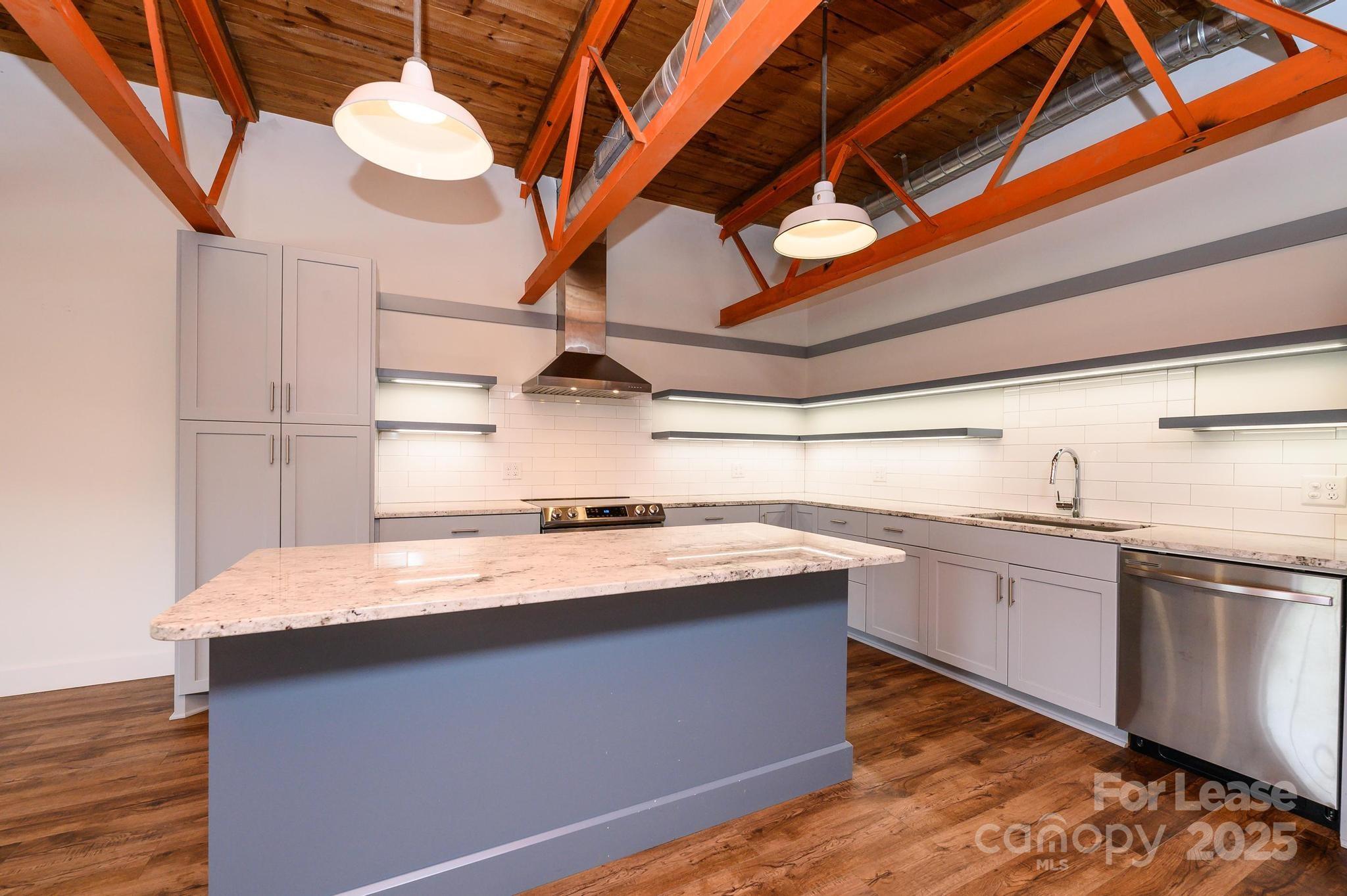 1001 West Avenue Northwest, Unit 1 Lenoir, NC 28645 - Photo 24 of 38 a kitchen with stainless steel appliances granite countertop a sink a stove and a wooden floors
