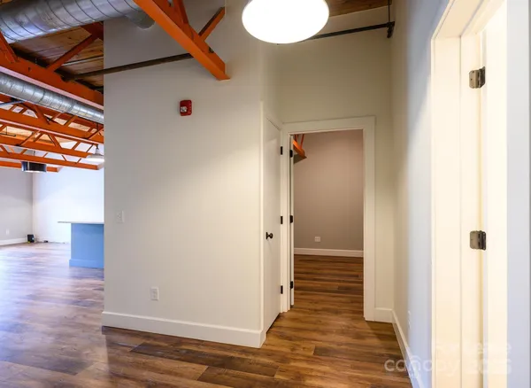 a view of a hallway with wooden floor and closet