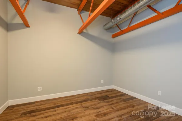 a view of a room with wooden floor and white walls