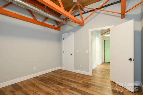 a view of a room with wooden floor and a ceiling fan