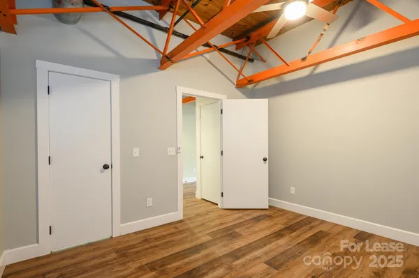 a view of a room with wooden floor and a ceiling fan