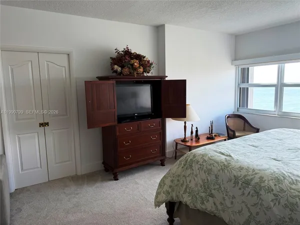 a bedroom with a bed and a flat screen tv
