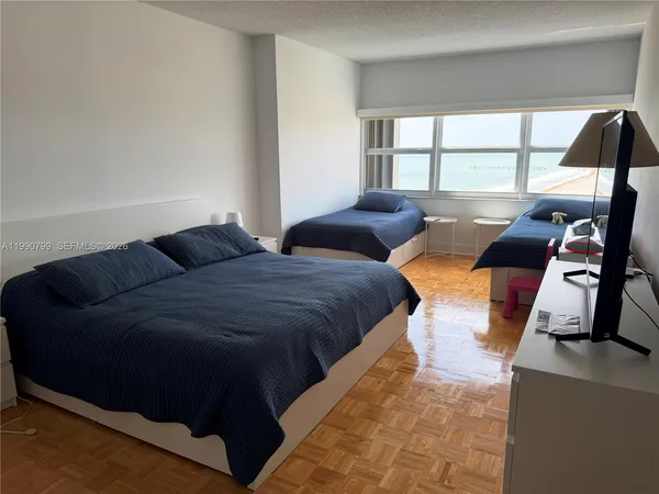 a large bedroom with bed and window