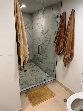 a bathroom with a granite countertop sink a toilet and a shower