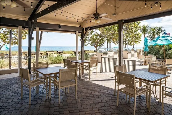 a dining room with furniture large windows and wooden floor