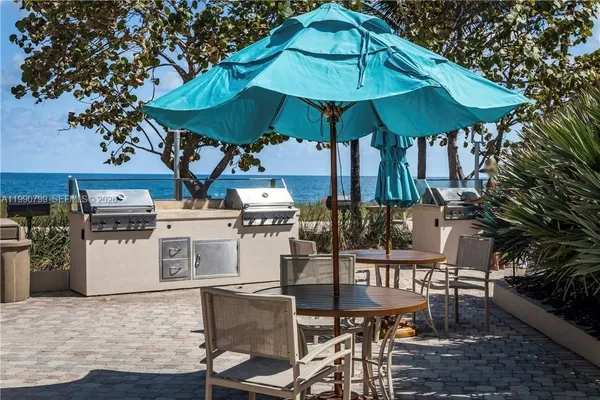 a patio with a table and chairs under an umbrella