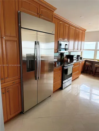 a kitchen with stainless steel appliances granite countertop a refrigerator a stove a sink and dishwasher