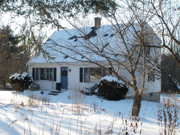 a front view of a house with a yard covered with snow