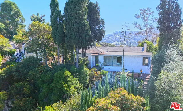 a front view of a house with a yard and fountain in middle