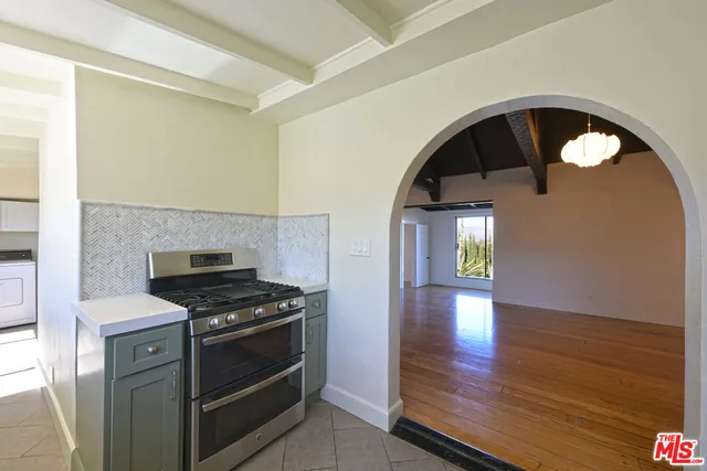 a kitchen with granite countertop a stove and a wooden floor