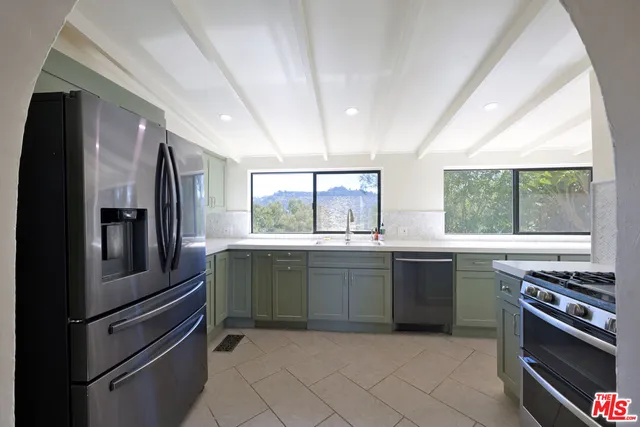 a kitchen with stainless steel appliances granite countertop a refrigerator and a stove
