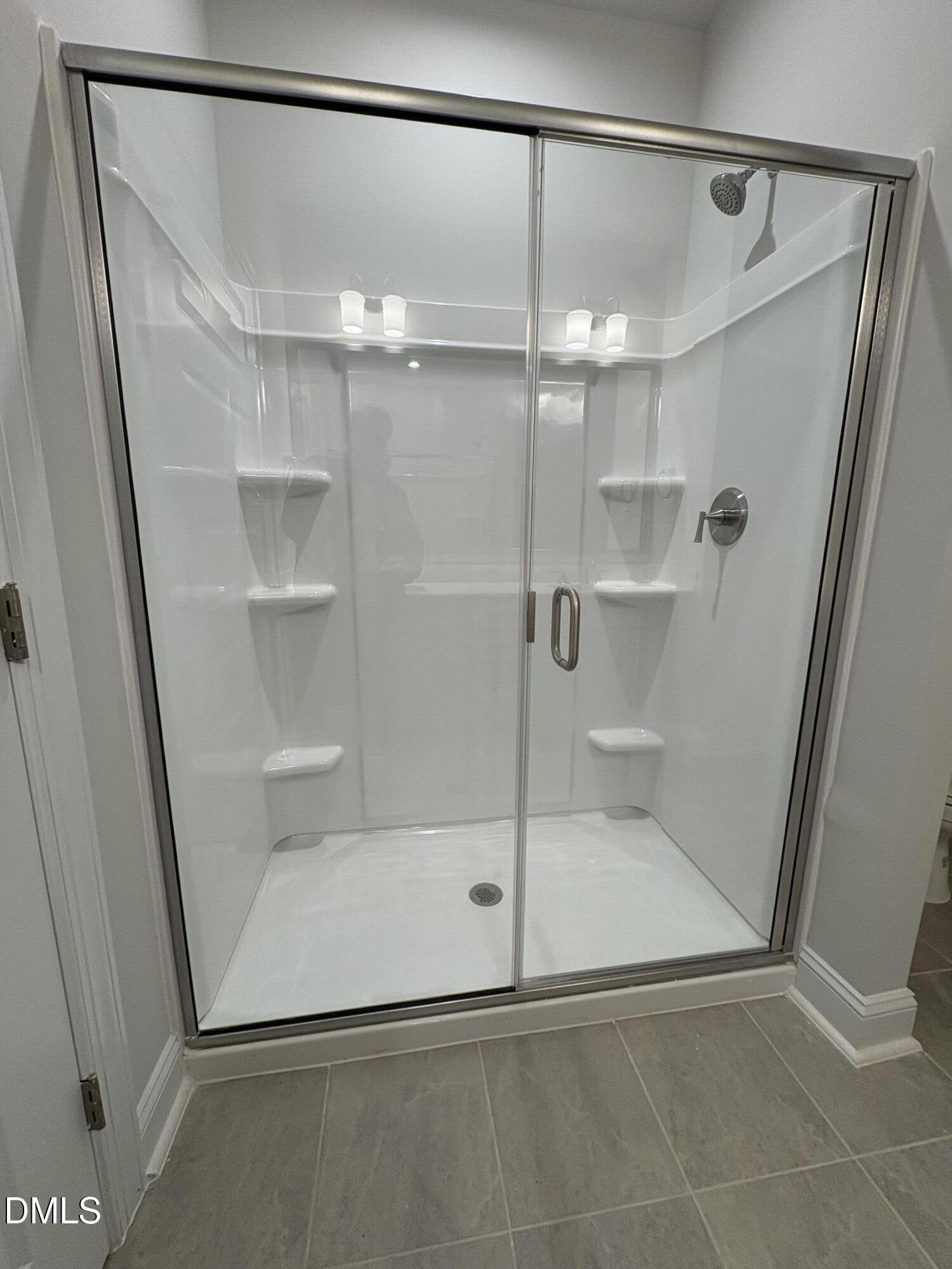 607 Weather Ridge Lane, Unit 24 Cary, NC 27513 - Photo 16 of 26 a bathroom with a glass shower door