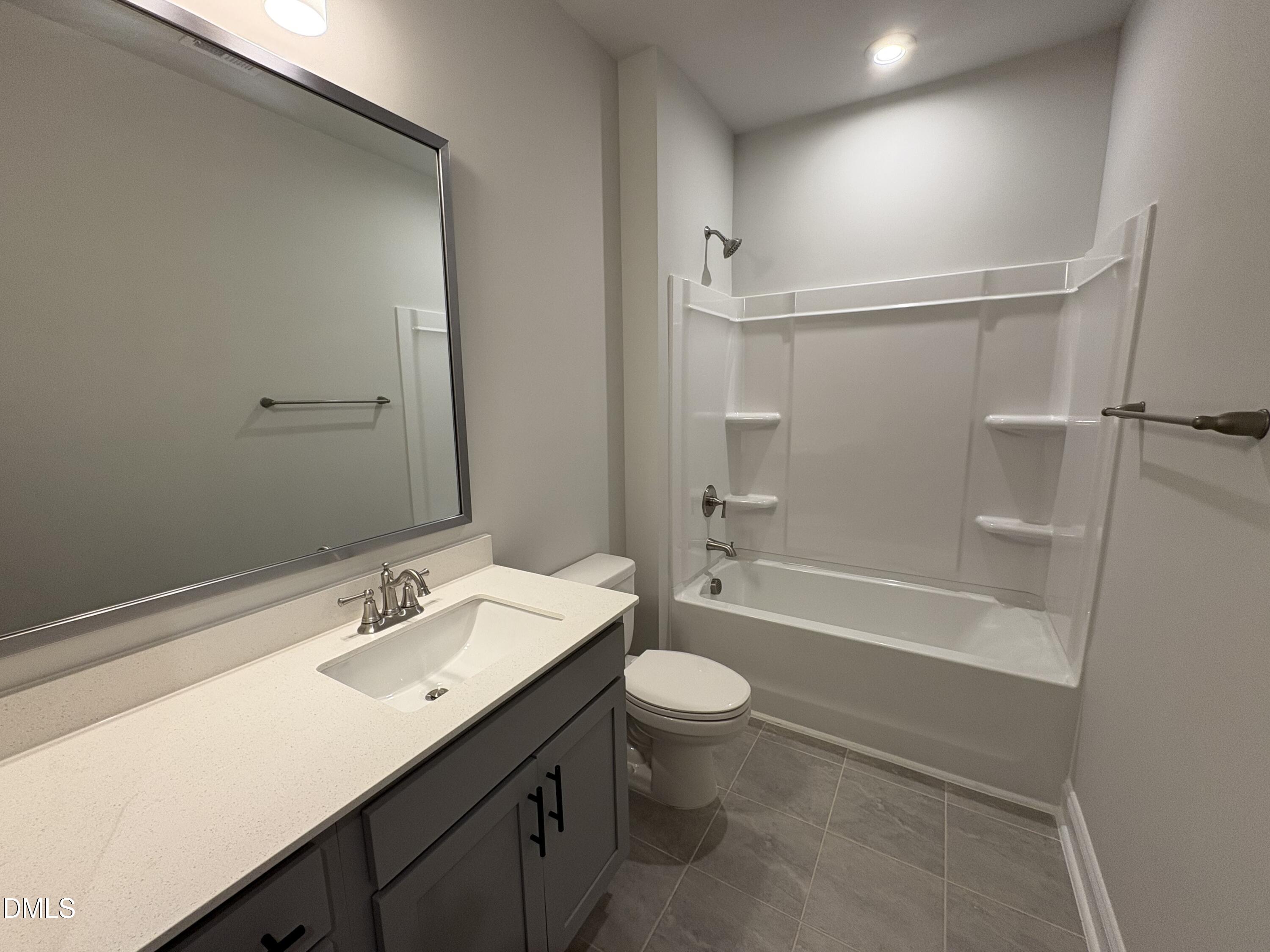 607 Weather Ridge Lane, Unit 24 Cary, NC 27513 - Photo 19 of 26 a bathroom with a sink a toilet a mirror and shower