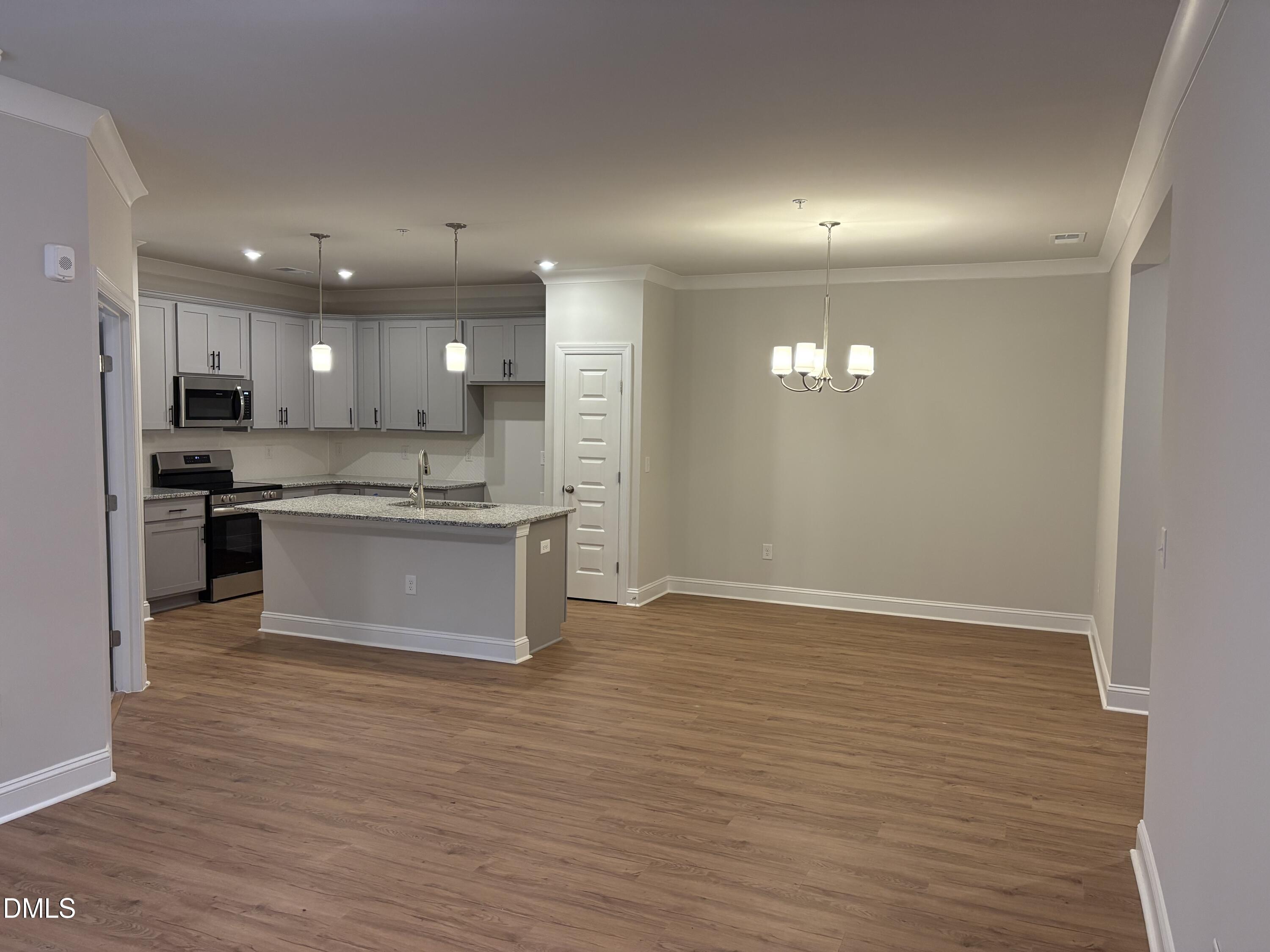 607 Weather Ridge Lane, Unit 24 Cary, NC 27513 - Photo 4 of 26 a large kitchen with stainless steel appliances granite countertop a stove a sink and a refrigerator