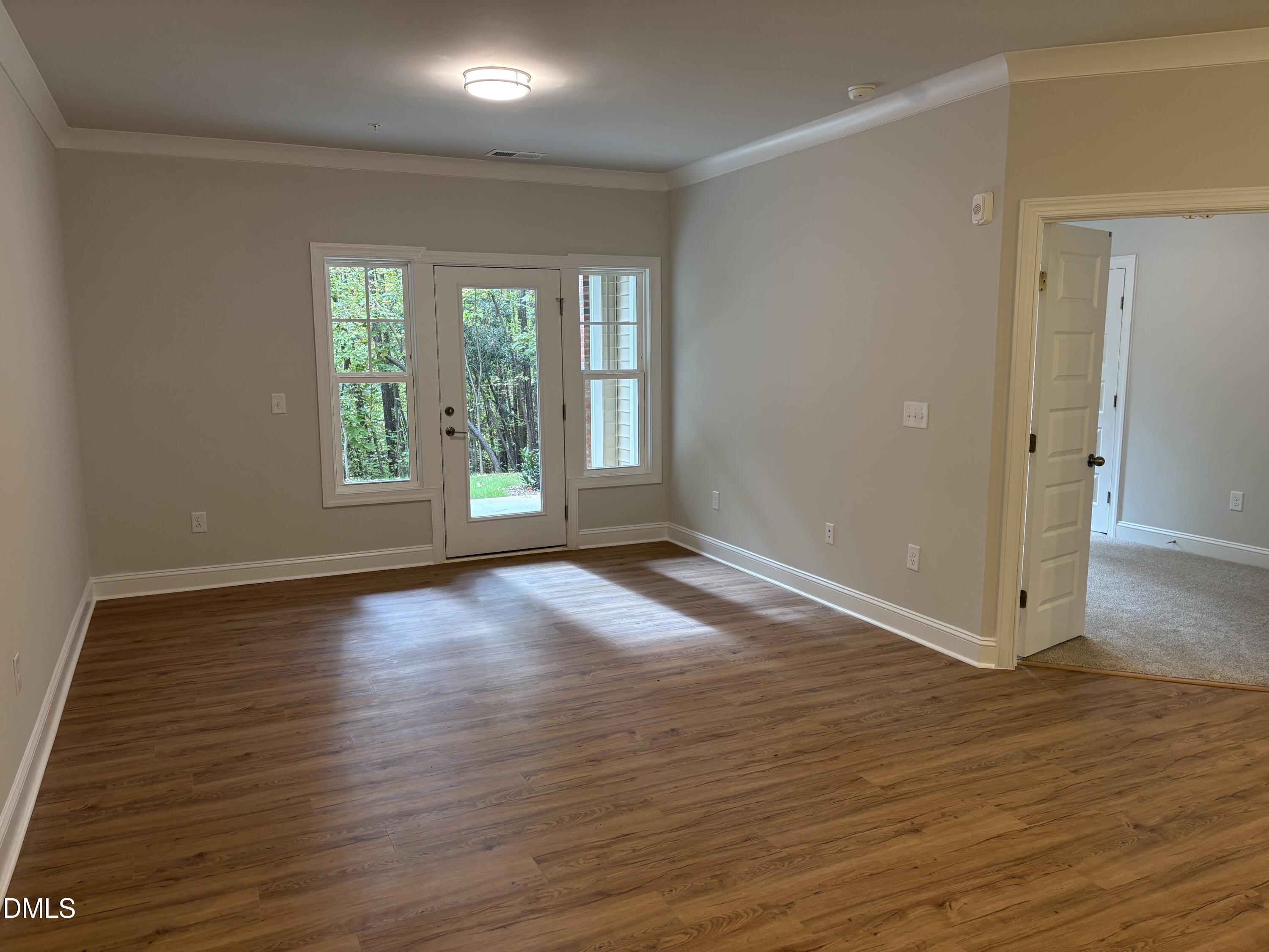 607 Weather Ridge Lane, Unit 24 Cary, NC 27513 - Photo 5 of 26 a view of an empty room with wooden floor and a window