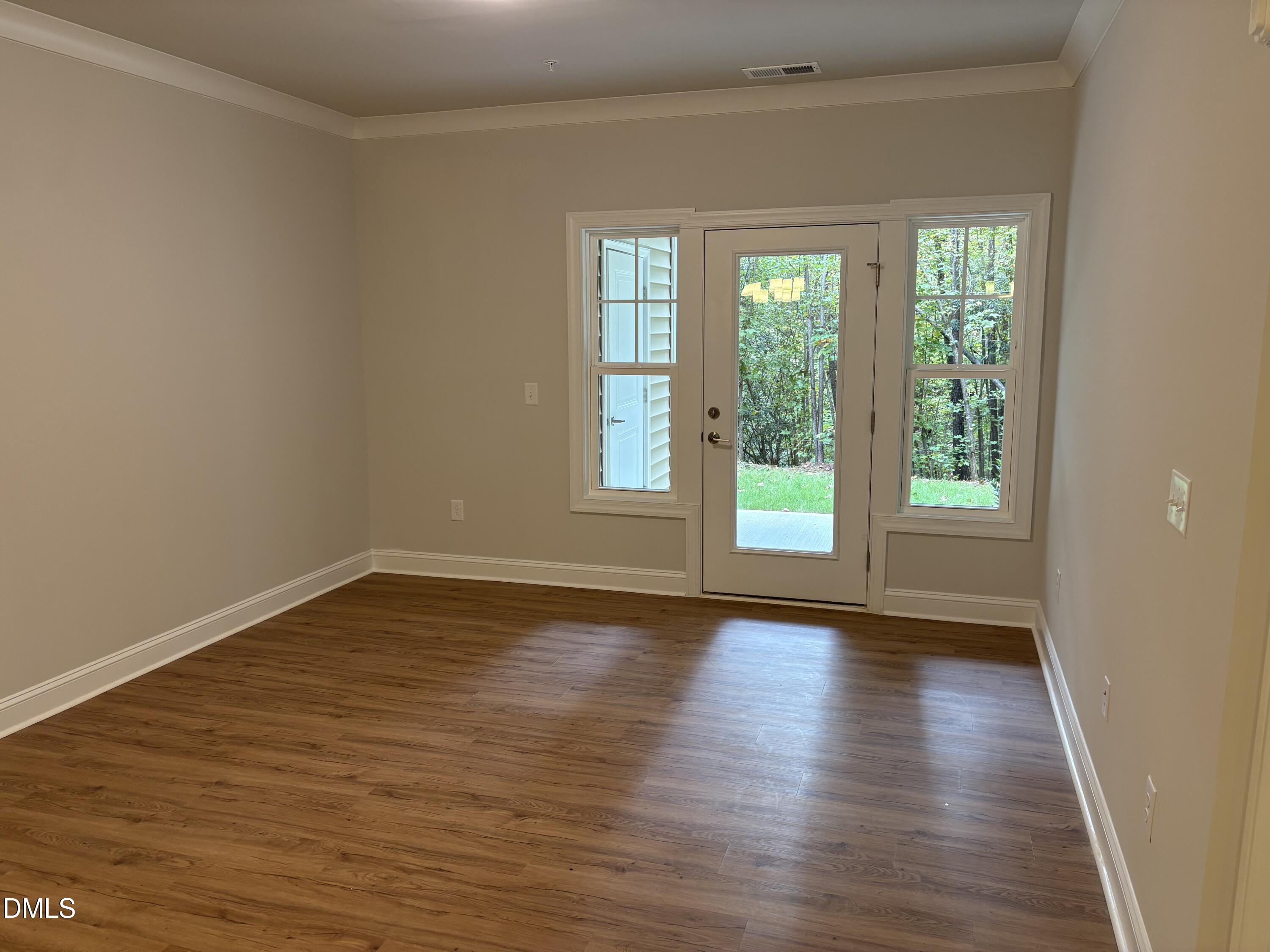 607 Weather Ridge Lane, Unit 24 Cary, NC 27513 - Photo 7 of 26 a view of an empty room with wooden floor and a window