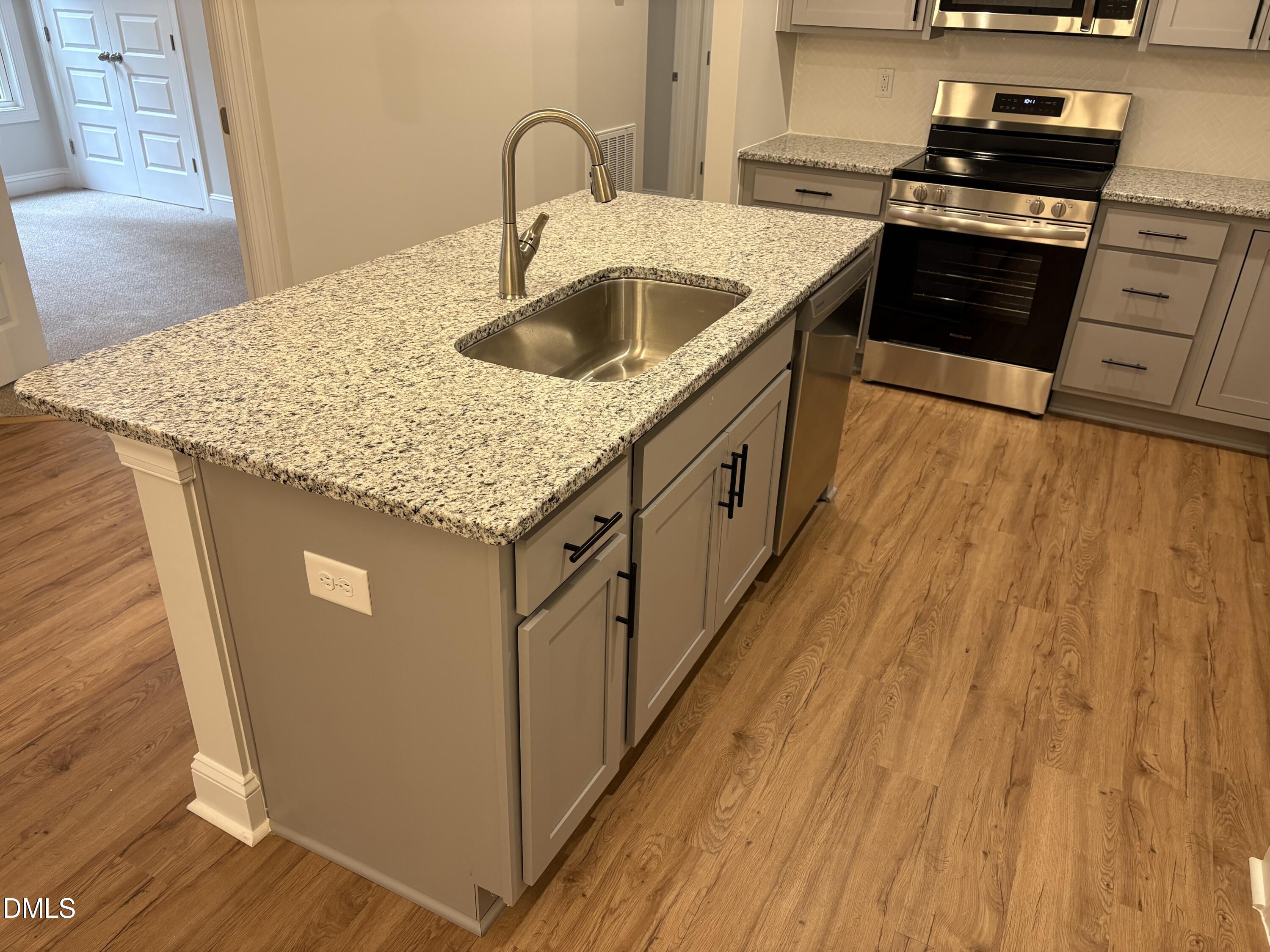 607 Weather Ridge Lane, Unit 24 Cary, NC 27513 - Photo 8 of 26 a kitchen with sink cabinets and wooden floor