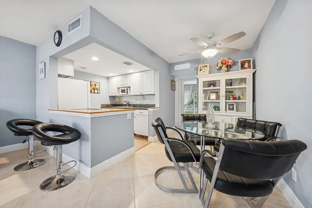 a kitchen with a dining table chairs and a refrigerator