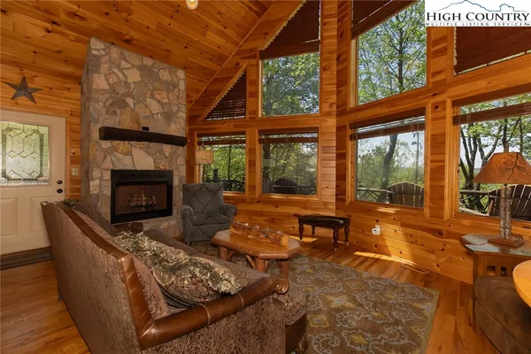 a living room with furniture a fireplace and a floor to ceiling window