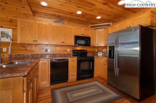 a kitchen with stainless steel appliances granite countertop a refrigerator and a stove