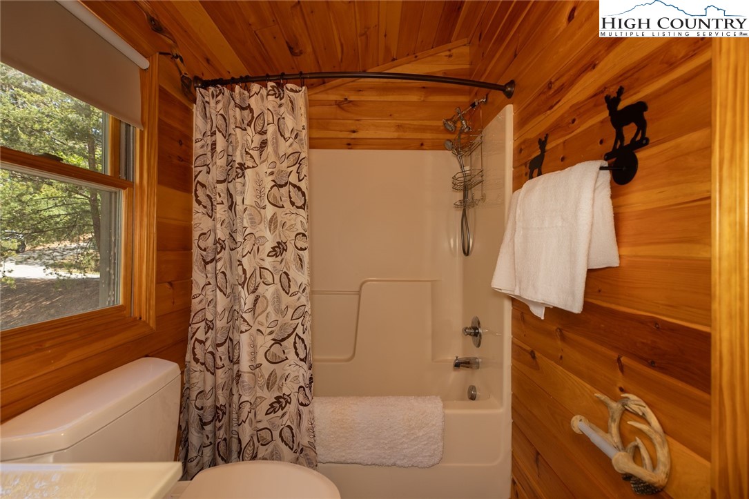 142 Fawn Lane Purlear, NC 28665 - Photo 28 of 49 a bathroom with a shower curtain and a bathtub