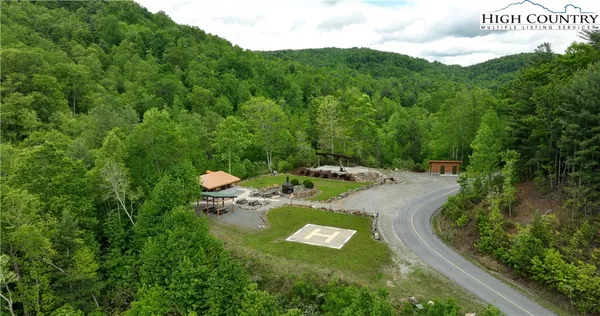 a front view of a house with lots of green space and trees