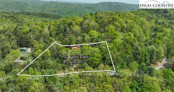a view of a balcony with floor to ceiling windows and wooden fence
