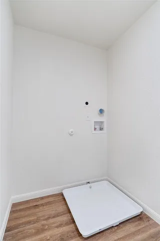 a view of a room with wooden floor and white walls