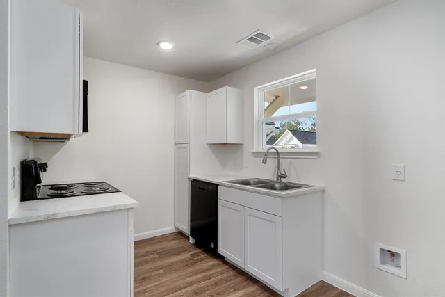 a kitchen with a sink cabinets and window