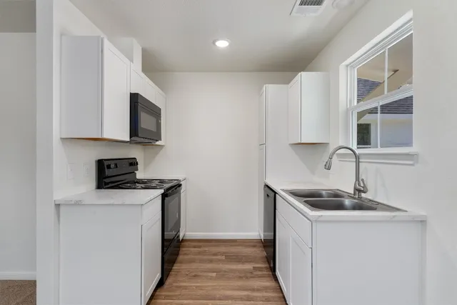 a kitchen with stainless steel appliances granite countertop a sink stove and microwave