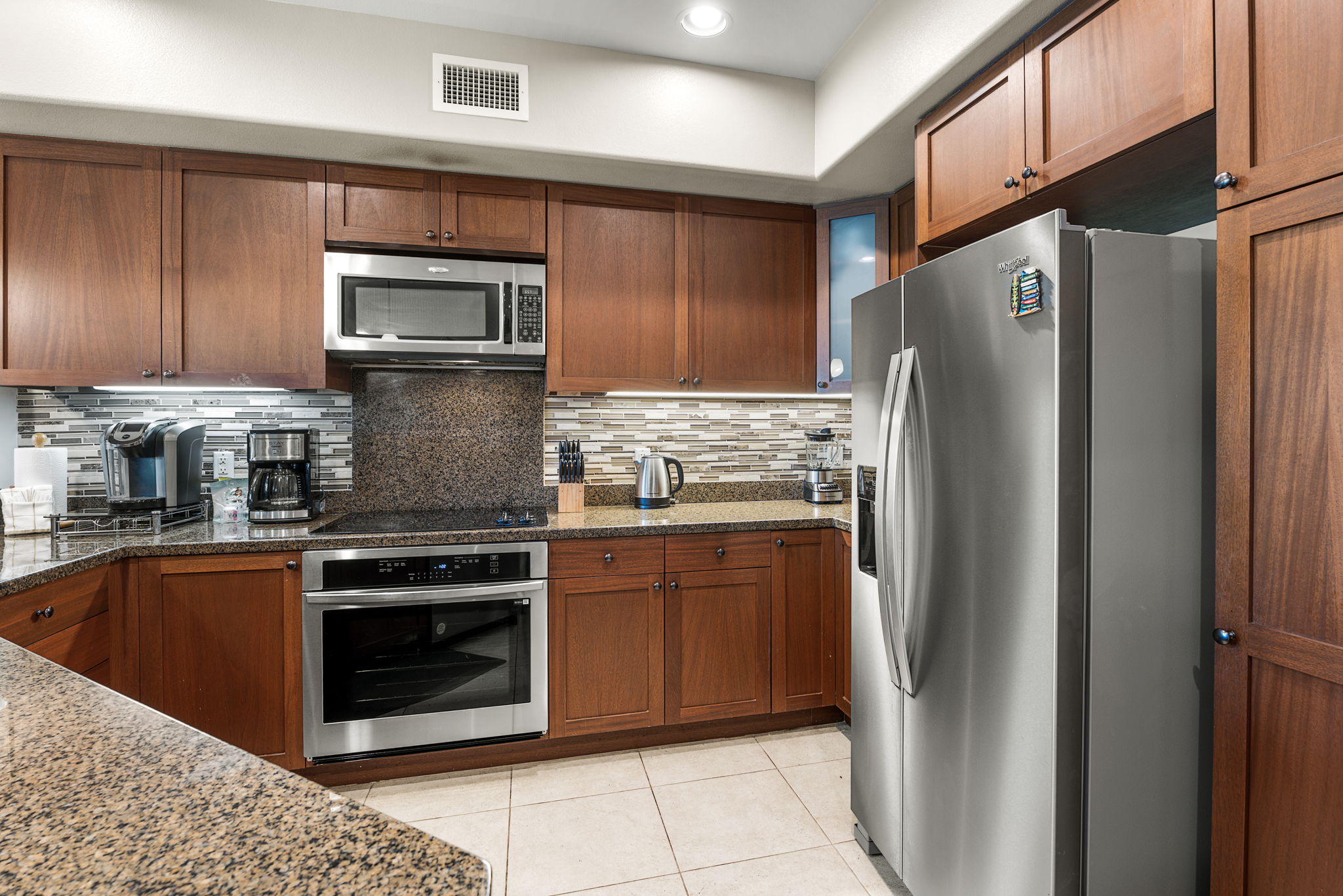 69-1033 Nawahine Place, Unit 22G Waikoloa, HI 96738 - Photo 4 of 30 a kitchen with stainless steel appliances granite countertop a refrigerator stove and microwave