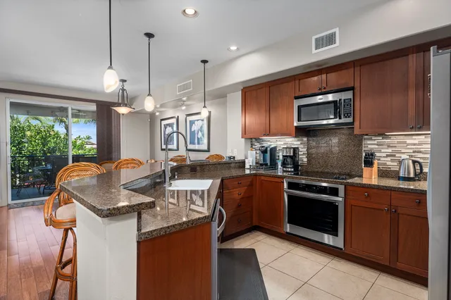a kitchen with granite countertop a stove sink and microwave