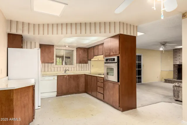 a kitchen with stainless steel appliances granite countertop a refrigerator and a stove top oven