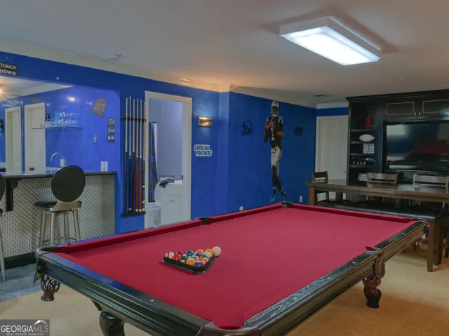a room with furniture pool table and flat screen tv