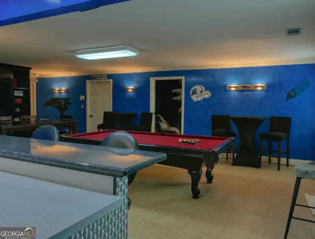 a room with pool table and wall paintings