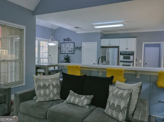 a living room with furniture and kitchen view