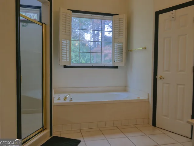a bathroom with a bathtub and next to a window