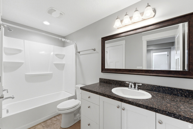 1614 Aspen Loop Provo, UT 84606 - Photo 32 of 47 Bathroom featuring a white tub/shower combination, dark speckled countertop, white vanity cabinetry, a framed vanity mirror, and recessed lighting