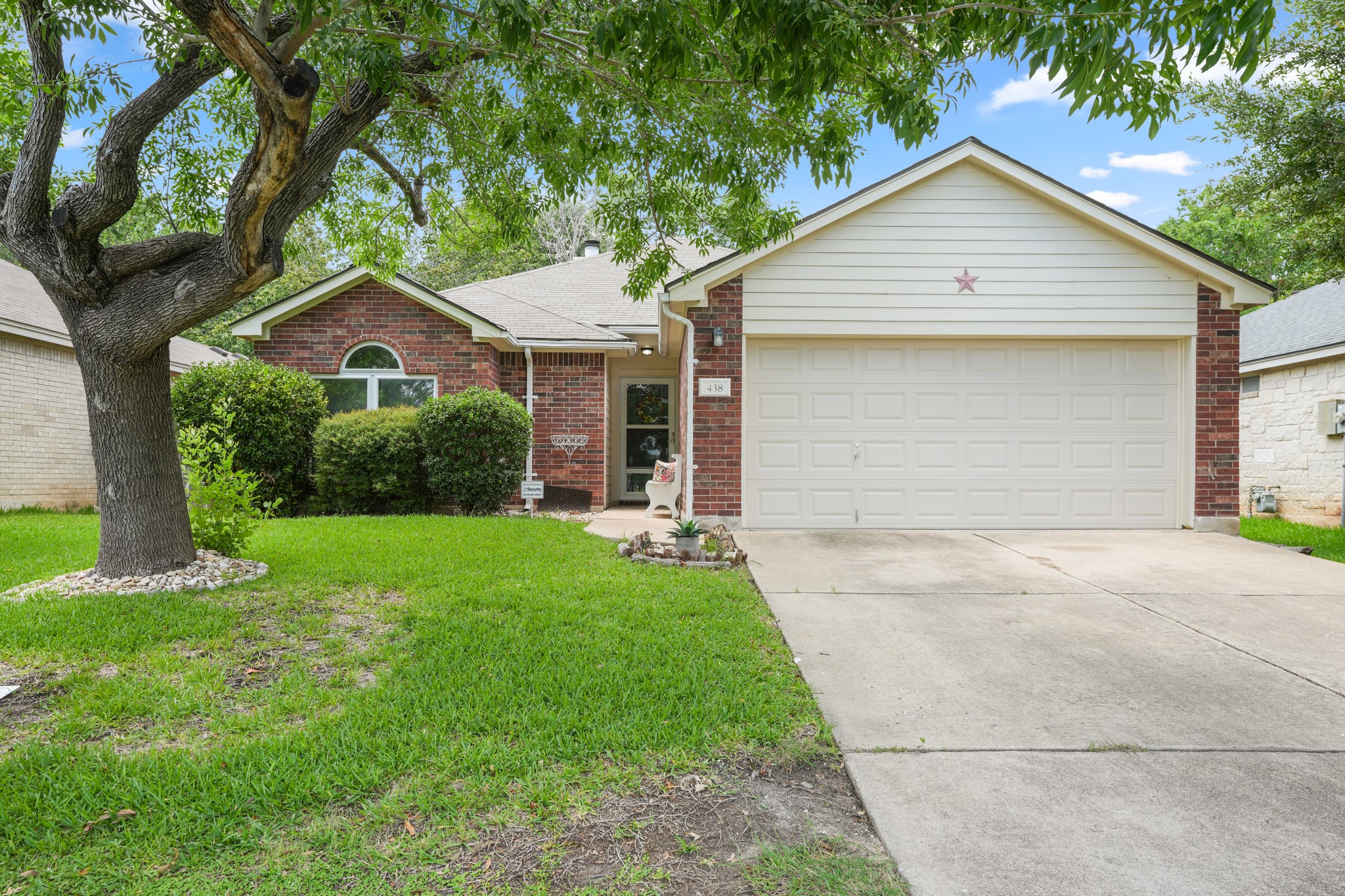 438 Katy Crossing Georgetown, TX 78626 - Photo 2 of 24 Mature trees and lush landscaping adorn this charming single-story residence with an attached garage.