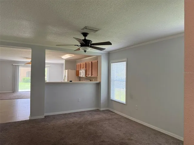 an empty room with a window and a fan