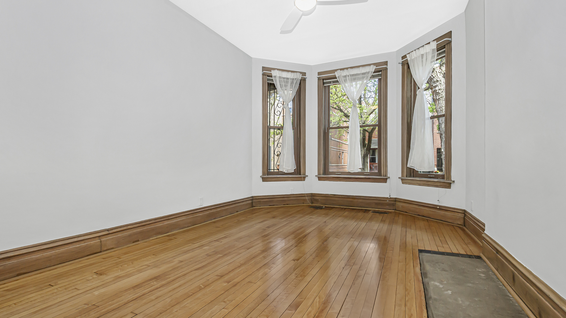 2619 West Rice Street Chicago, IL 60622 - Photo 44 of 65 a view of an empty room with wooden floor and a window