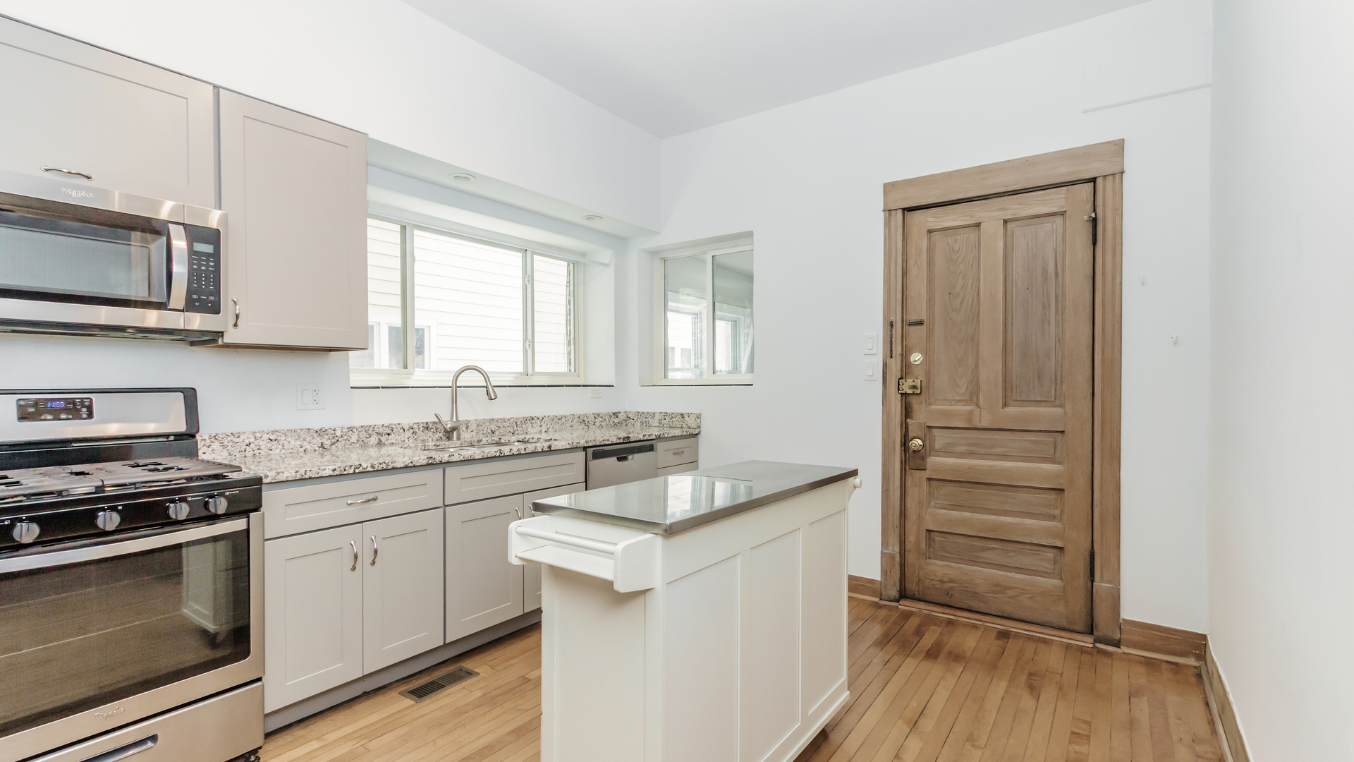 2619 West Rice Street Chicago, IL 60622 - Photo 54 of 65 a kitchen with granite countertop cabinets appliances and a wooden floor