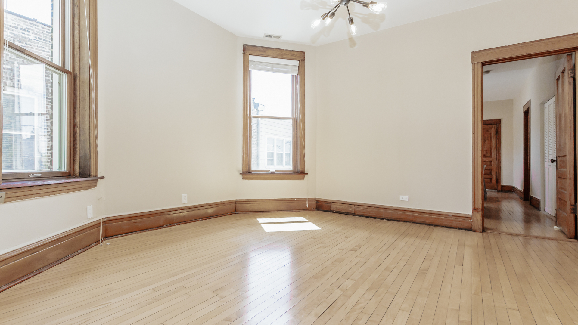 2619 West Rice Street Chicago, IL 60622 - Photo 8 of 65 an empty room with wooden floor and windows
