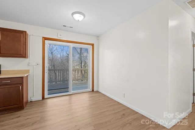 a view of empty room with wooden floor and fireplace